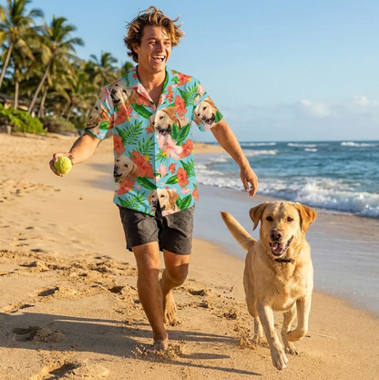 Mann in personalisiertem Hawaiihemd mit Hund am Strand, bei sonnigem Wetter. Hemd mit bunten Blumen- und Hundemotiven.
