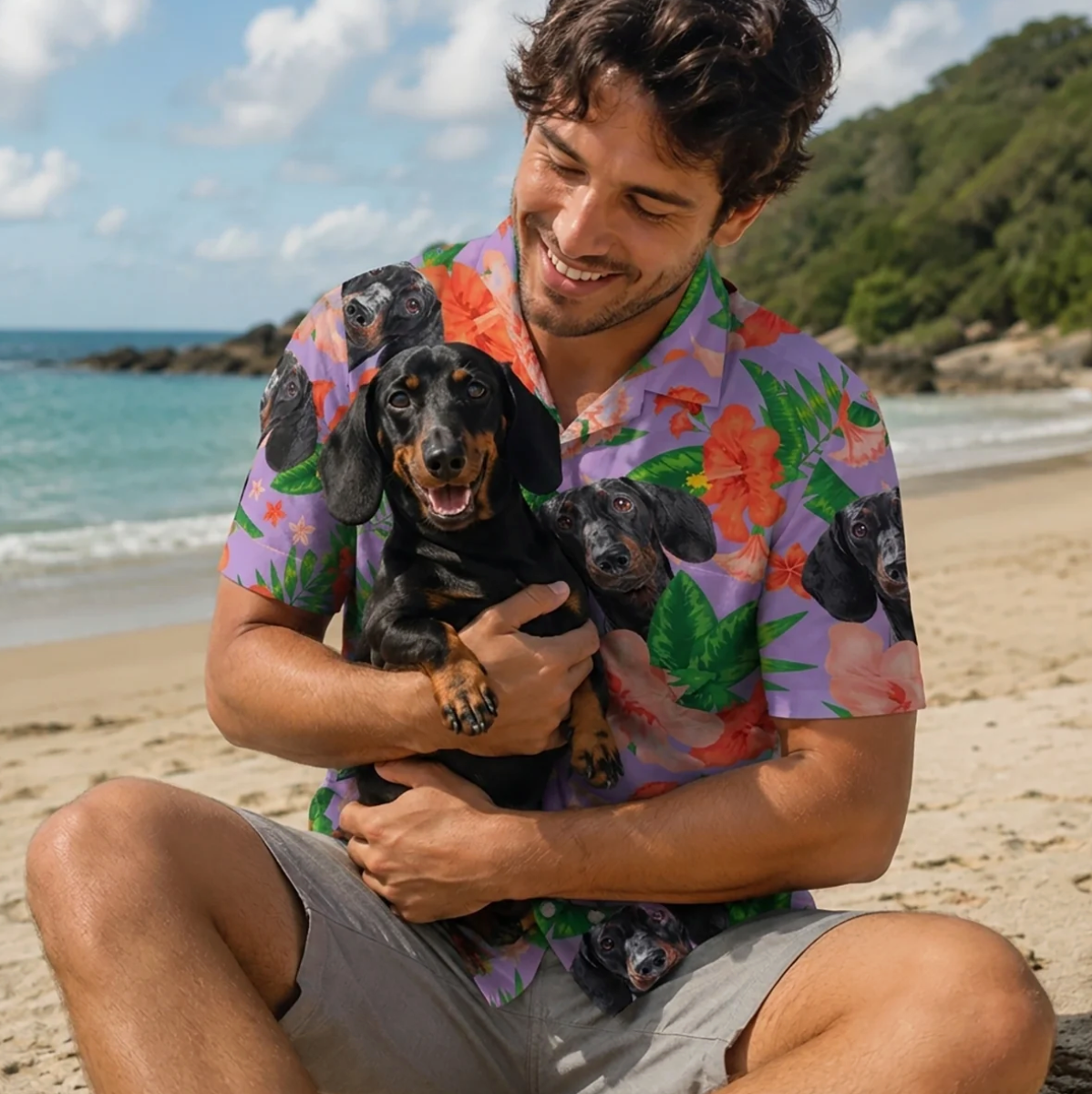 Mann hält einen Hund und trägt ein personalisiertes Hawaiihemd mit buntem Muster am Strand.