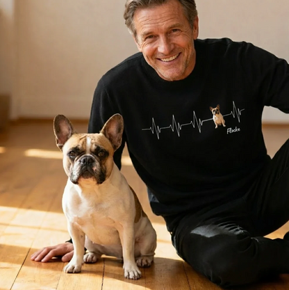 Personalisiertes schwarzes Sweatshirt mit Herzschlag-Motiv und Hundebild. Ein Mann sitzt neben einem Hund.