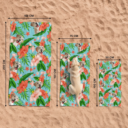 Drei personalisierte Strandtücher mit Hundemotiv und farbenfrohen Blumen auf sandigem Untergrund.
