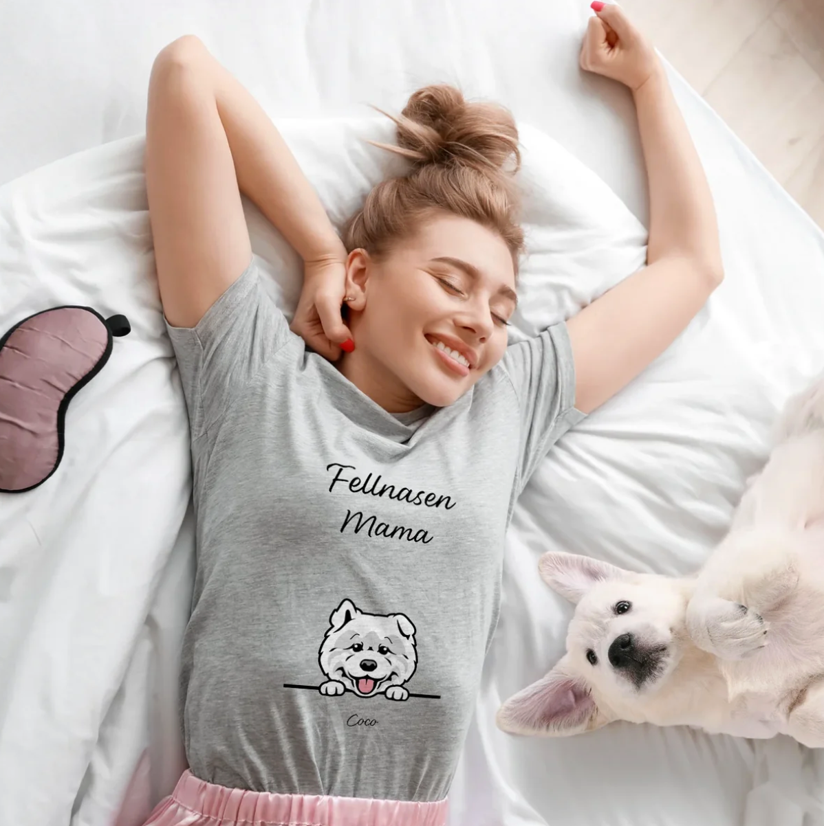 Graues T-Shirt mit Aufdruck "Fellnasen Mama" und Hundemotiv, getragen von einer lächelnden Frau im Bett.