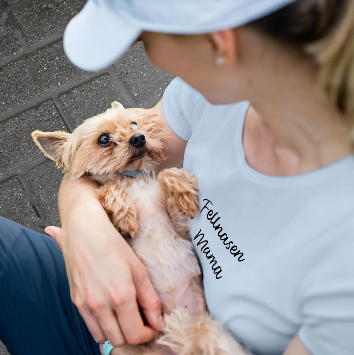 Blaue T-Shirt mit dem Schriftzug "Fellnasen Mama", getragen von einer Person, die einen Hund hält.