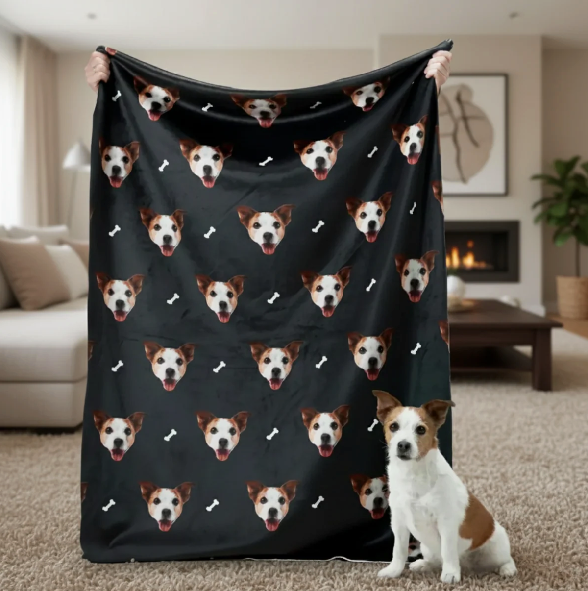 Personalisierte Decke mit Haustierköpfen auf schwarzem Hintergrund, gehalten von einer Person mit einem Hund im Vordergrund.