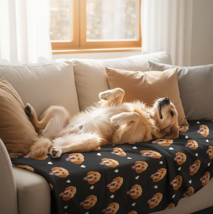Eine personalisierte Decke mit Hundeköpfen auf schwarzem Hintergrund, dekoriert mit Herzen, auf einem Sofa.