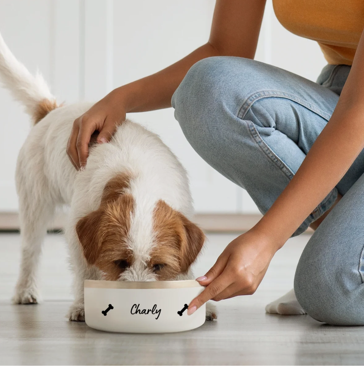 Hund frisst aus personalisiertem, weißem Napf mit dem Namen "Charly" und Knochenmotiven.