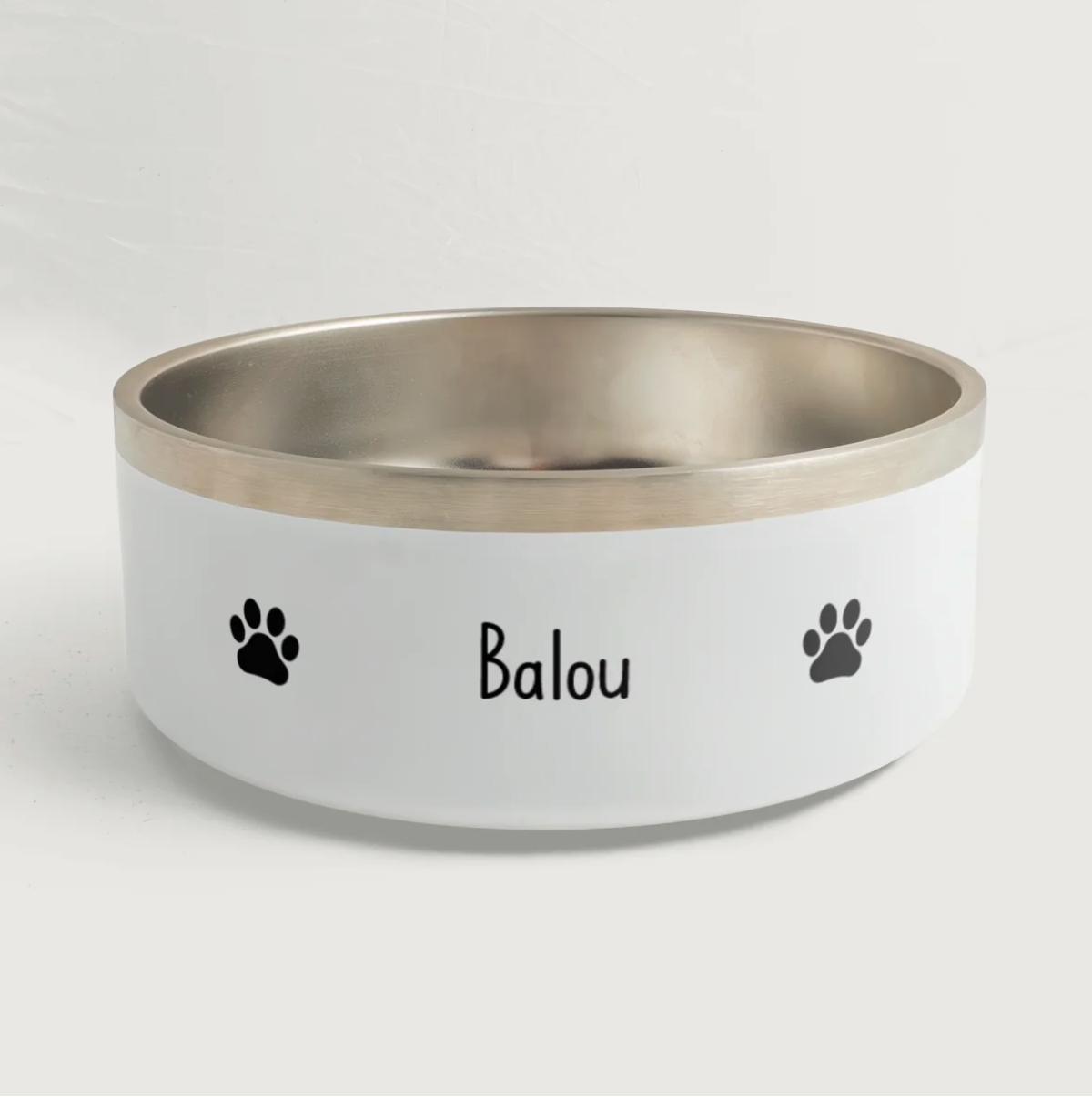 Personalisierter Tiernapf mit silbernem Rand und dem Namen "Balou" sowie Pfotenabdrücken in Schwarz.