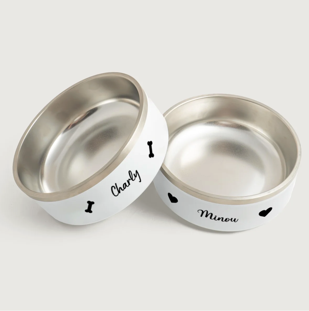 Personalisierte Tiernapfe aus Edelstahl mit weißen Außenflächen und Namen, Charly und Minou, bedruckt.