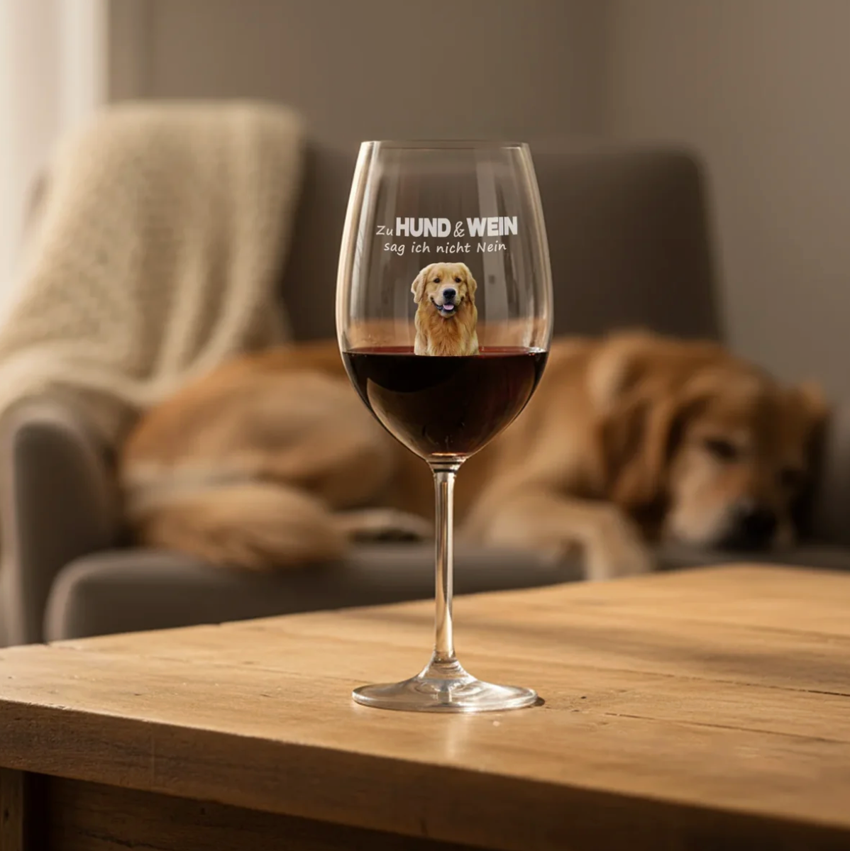 Personalisiertes Weinglas mit Hundemotiv und Schriftzug, gefüllt mit Rotwein auf einem Holztisch.