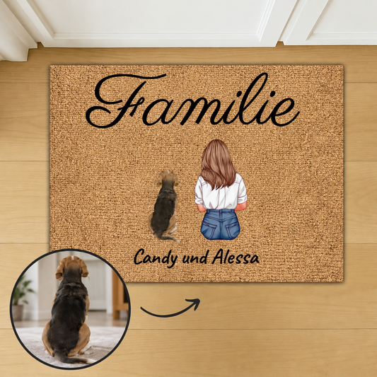 Personalisierte Fußmatte aus Kokosfaser mit der Aufschrift "Familie" und Illustrationen einer Frau und einem Hund.