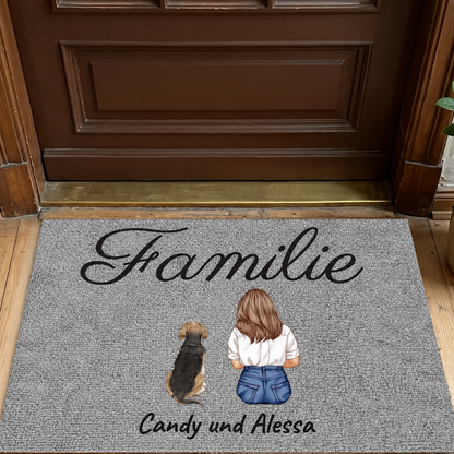 Personalisierte Fußmatte mit grauer Oberfläche, Aufdruck von „Familie“ und Illustrationen eines Mädchens mit Hund.
