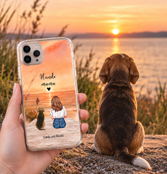 Transparente Handyhülle mit Kunstmotiv einer Person und Hund am Strand bei Sonnenuntergang.