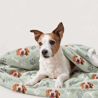 Personalisierte Haustierdecke mit grünem Hintergrund und aufgedruckten Hundemotiven, umhüllt von einem Hund.