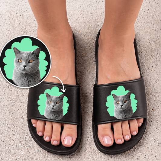 Schwarze Badelatschen mit personalisiertem Katzenportrait in Grau auf grünem Hintergrund.