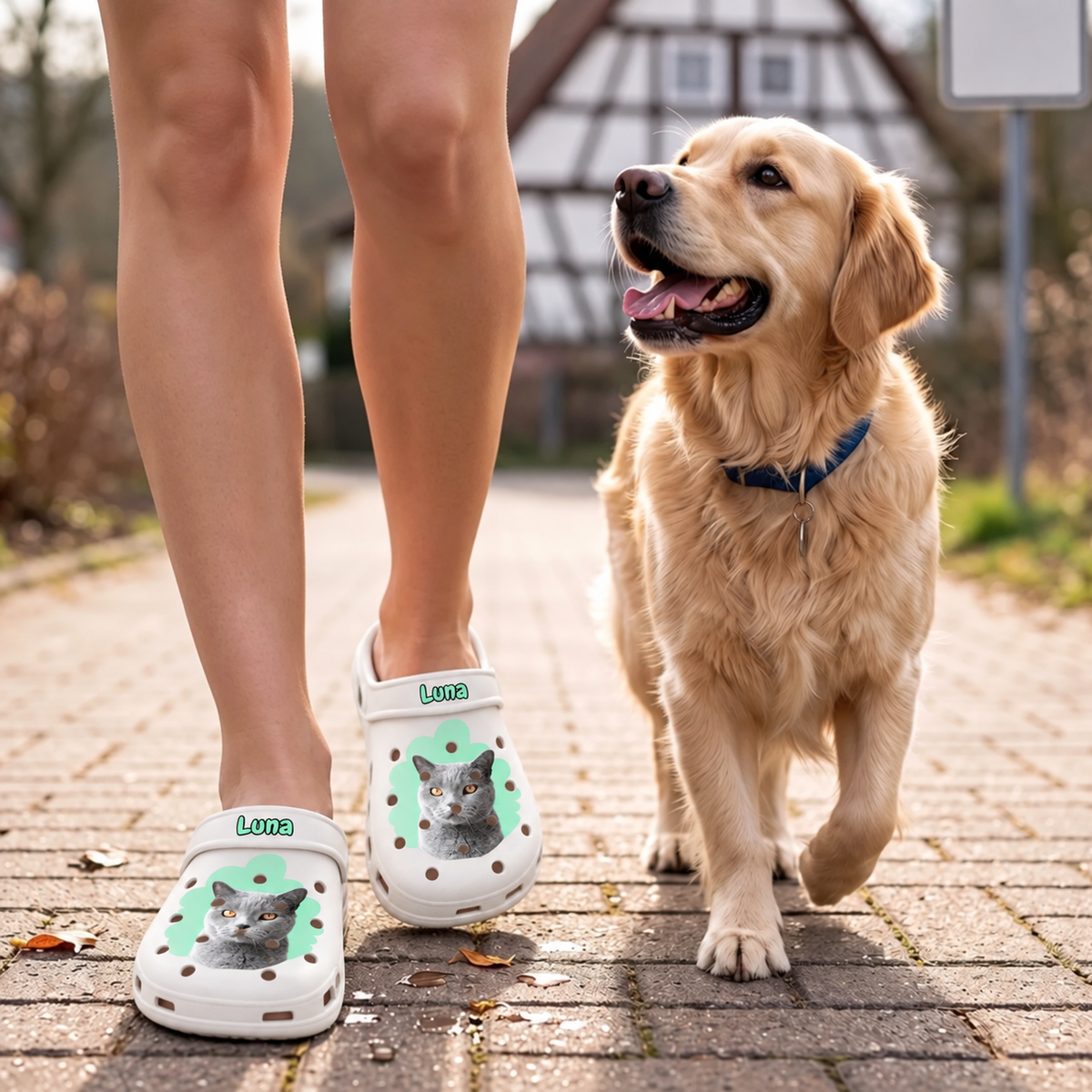Personalisierte weiße Clogs mit Haustierportrait einer Katze, getragen von einer Person, die mit einem Hund spazieren geht.