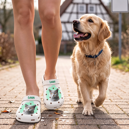 Personalisierte weiße Clogs mit Haustierportrait einer Katze, getragen von einer Person, die mit einem Hund spazieren geht.