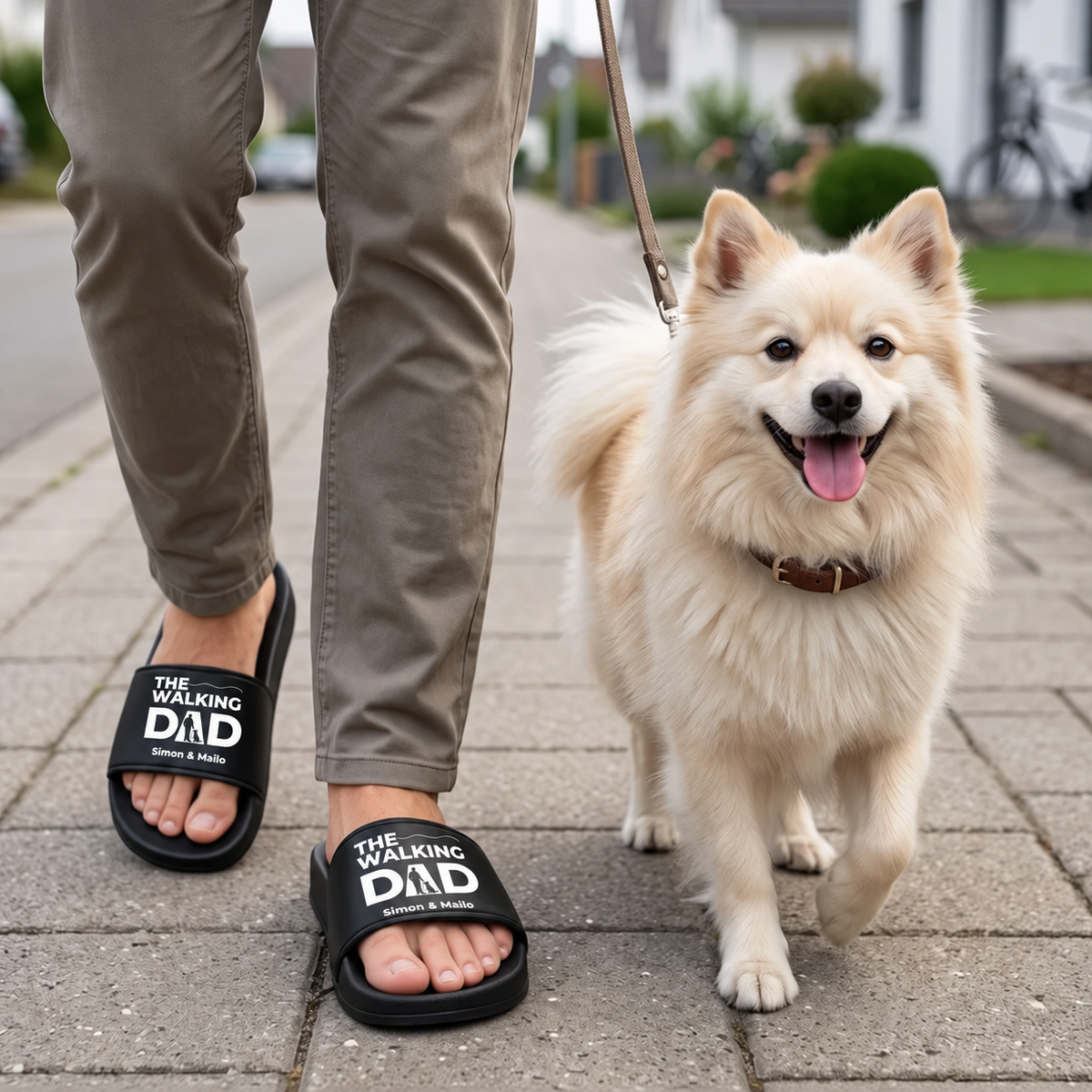 Person trägt personalisierte Badelatschen in Schwarz mit dem Aufdruck "THE WALKING DAD" und geht mit einem Hund.